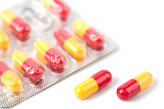 red and yellow capsule pills in blister isolated