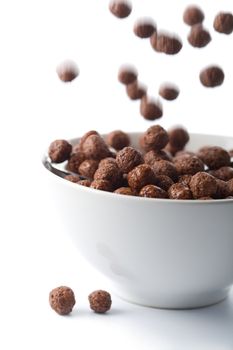 chocolate balls falling into bowl isolated