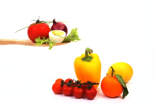 Ingredients to make a healthy salad, presented on a wooden spoon