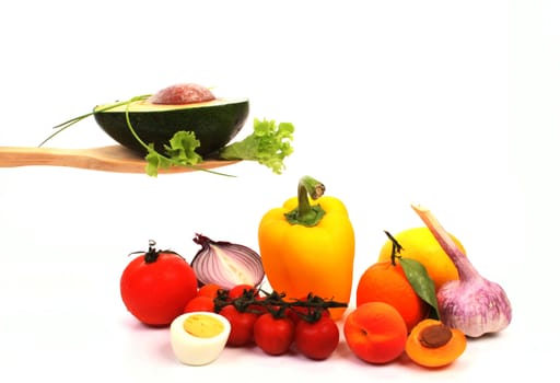 Ingredients to make a healthy salad, presented on a wooden spoon