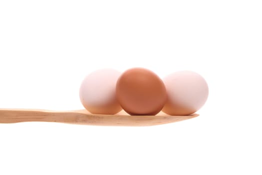Eggs simply offered on a wooden spoon isolated on a white background 