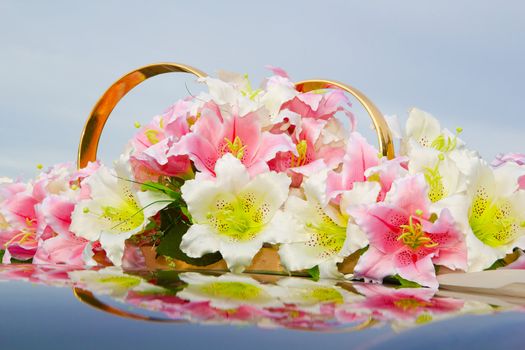 Wedding decoration of flowers and rings on the roof of the car