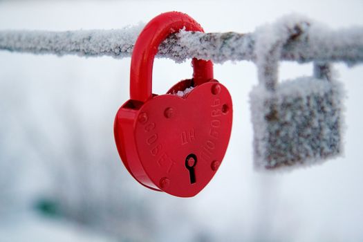 Wedding lock on a bridge covered with frost