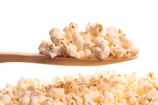 Popcorn  simply offered on a wooden spoon isolated on a white background 