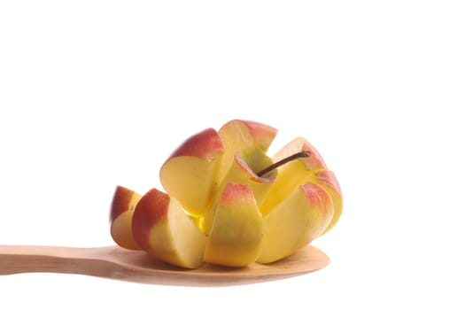 Cut apple  simply offered on a wooden spoon isolated on a white background 