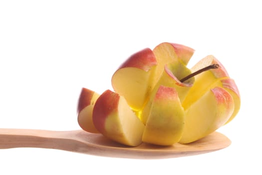 Cut apple  simply offered on a wooden spoon isolated on a white background 