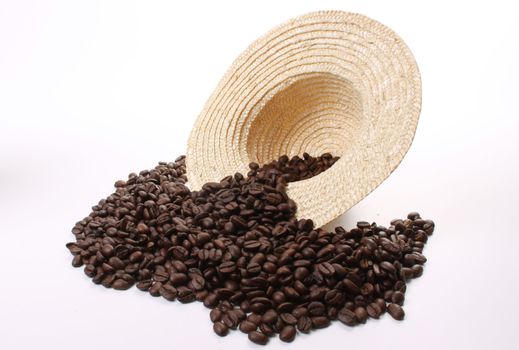 Roasted coffee beans  and a coffee cup and a straw hat