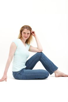 Girl sitting up straight but comfortable on the floor leaning her elbow on a knee.