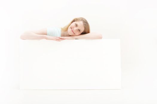 Pretty blonde girl smiling and looking very self assured over a white poster board with blank space for your message