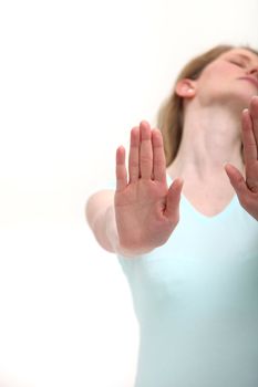 Woman throwing back her head in abandonment and rejection giving a Stop Now gesture with her hands raised palm outwards.