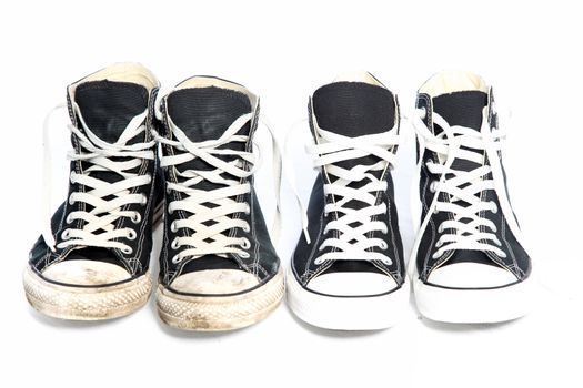 Two pairs of identical lace up blue canvas sneakers - one old with discolouration and dirt and one new