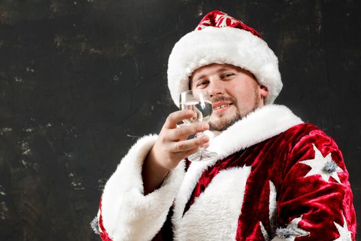 Santa Claus is preparing to celebrate Christmas. Drinking wine