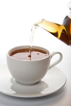 tea pouring into white cup isolated
