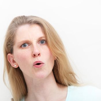 Young woman showing mild shock with her mouth open after hearing recent news