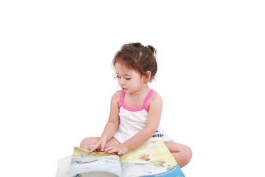 Beautiful toddler girl reading a book