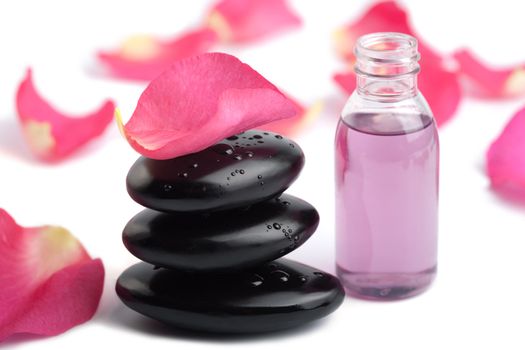 spa stones, essential oil and rose petals isolated