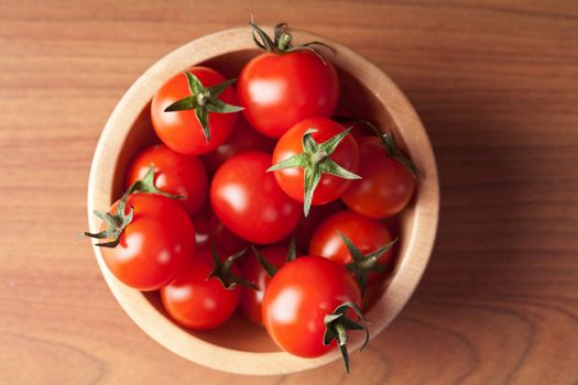 ripe tomatoes in wooden bowl