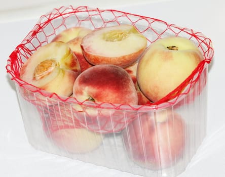 peaches in the package on a white background