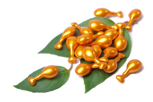 cosmetic capsules over leaves isolated