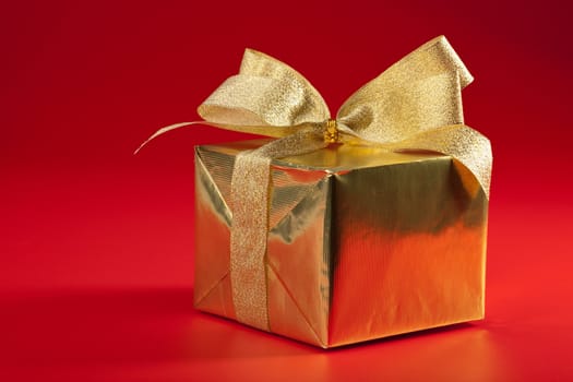 golden gift box over red background