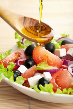 olive oil pouring over salad

