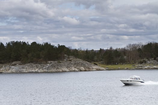 landscape in norway - coastline in fjord with small boat