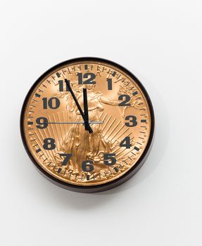 Concept of time is money from a wall clock close to midnight made from gold coin