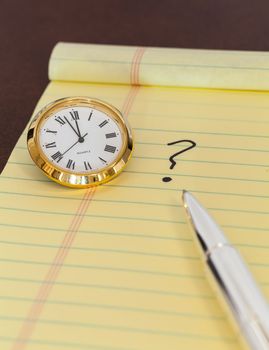 Concept for urgent decision making with clock on paper and question mark on pad