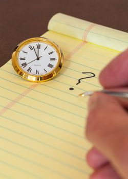 Concept for urgent decision making with clock on paper and question mark on pad