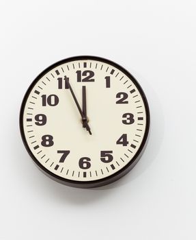 Brown simple plastic wall clock on the wall of office and concept of running out of time