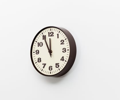 Brown simple plastic wall clock on the wall of office and concept of running out of time