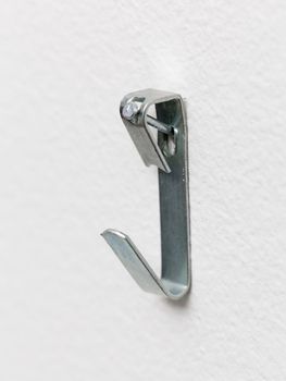 Close up of a metal picture hook nailed to plaster wall ready to mount a picture frame