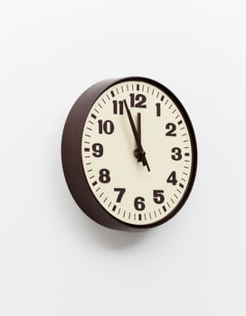 Brown simple plastic wall clock on the wall of office and concept of running out of time