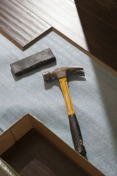 Hammer and Block with New Laminate Flooring Abstract.