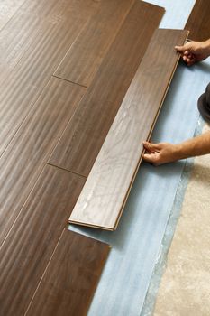 Man Installing New Laminate Wood Flooring Abstract.