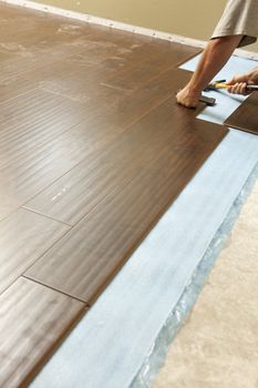 Man Installing New Laminate Wood Flooring Abstract.