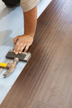 Man Installing New Laminate Wood Flooring Abstract.