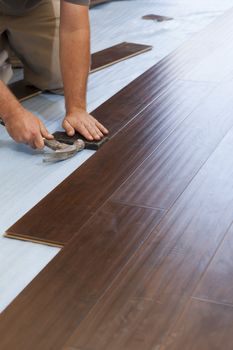 Man Installing New Laminate Wood Flooring Abstract.