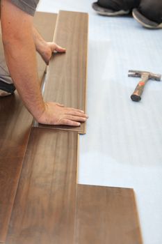 Man Installing New Laminate Wood Flooring Abstract.