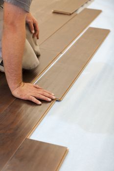 Man Installing New Laminate Wood Flooring Abstract.