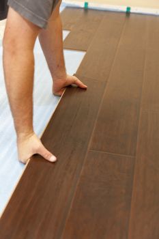 Man Installing New Laminate Wood Flooring Abstract.