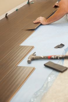 Man Installing New Laminate Wood Flooring Abstract.