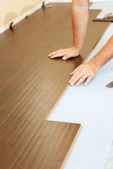 Man Installing New Laminate Wood Flooring Abstract.