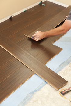 Man Installing New Laminate Wood Flooring Abstract.