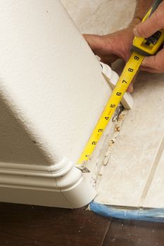 Contractor Measuring for New Baseboard with Bull Nose Corners and New Laminate Flooring Abstract.