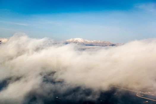 view of the mountains from an airplane above the clouds