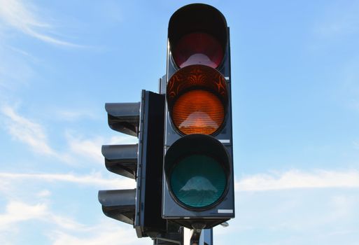 Yellow color on traffic light with beautiful blue sky in background