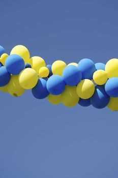 Yellow and blue color balloons on background of blue sky.