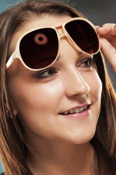teenager lifting her sunglasses looking to side