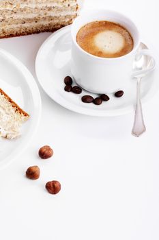 coffee with a hazelnut cream cake from top on white background
